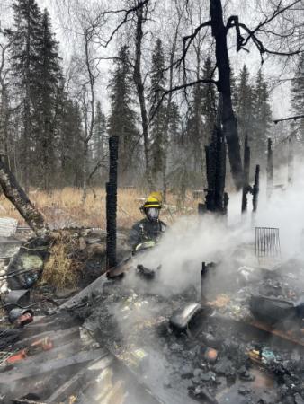 Photo of a person in fire protection gear at the site of a fire
